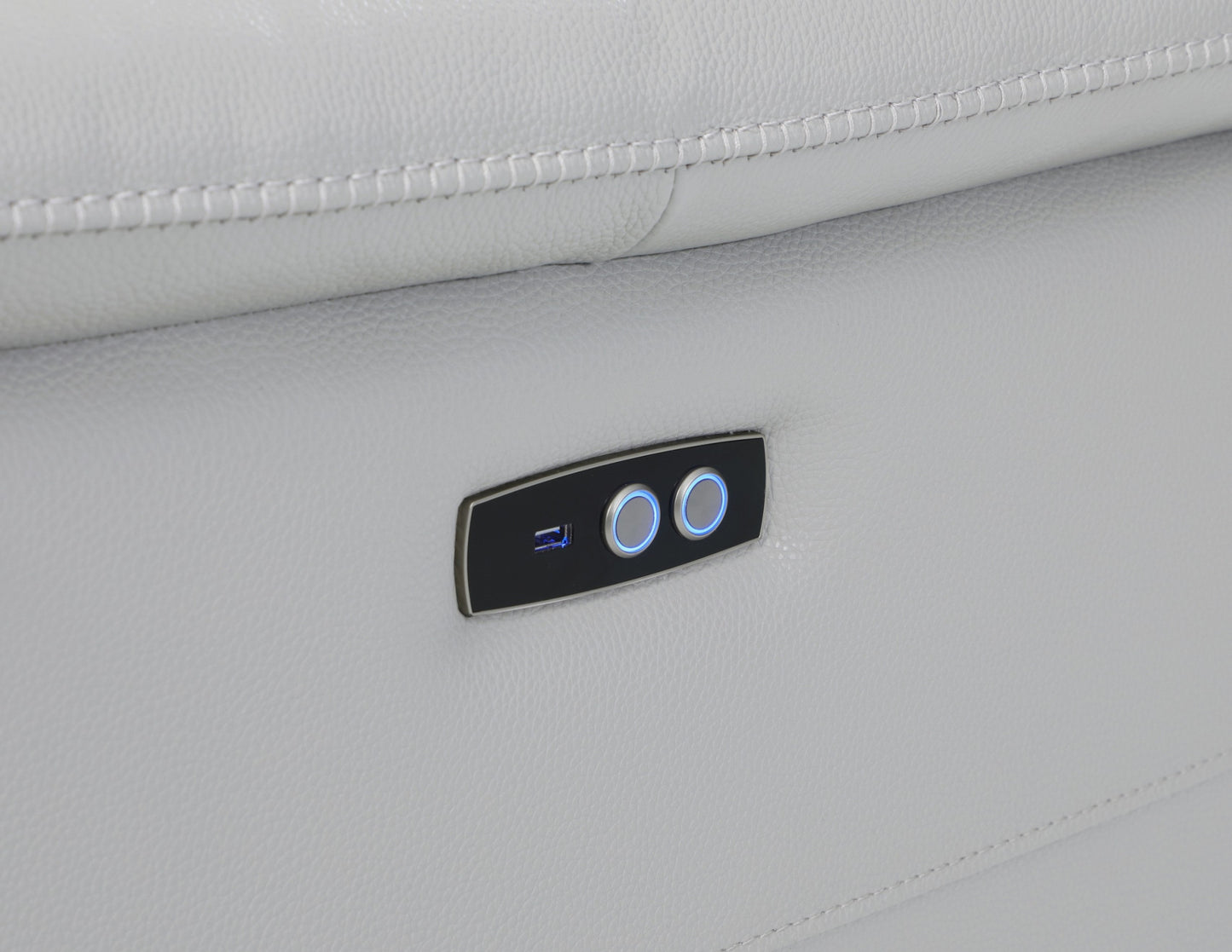 Close-up of the power recline control panel on a light gray leather sectional sofa, featuring illuminated buttons for smooth electric reclining. Highlighting ease of use for ultimate comfort control.