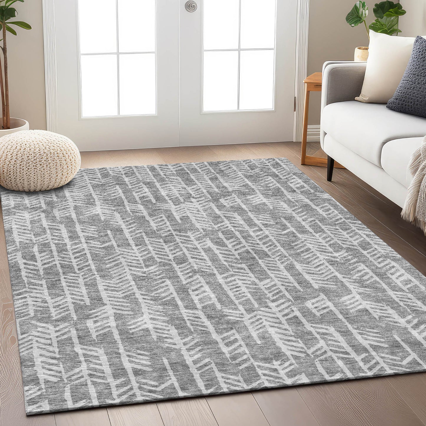 A modern gray area rug with a hand-carved, textured geometric pattern, perfect for a living room or bedroom. The rug features an abstract herringbone design in white and various shades of gray.
